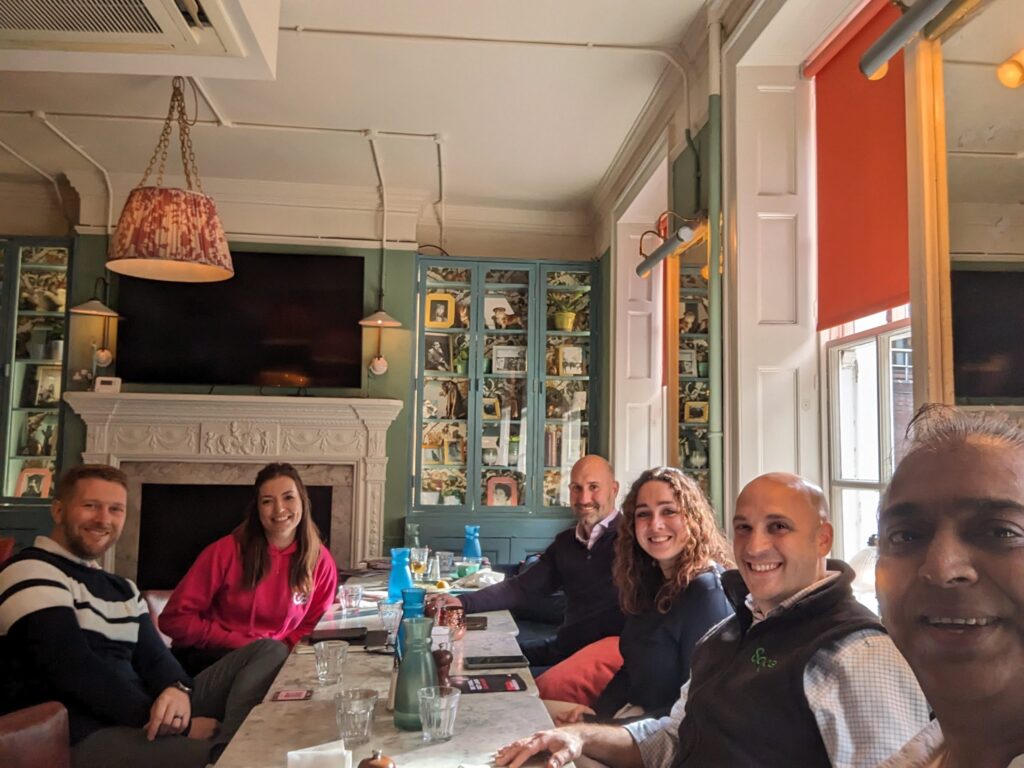 Vivek with his clients at a restaurant where he's talking CXM solutions through personalised service and Zoho CRM Plus insights.