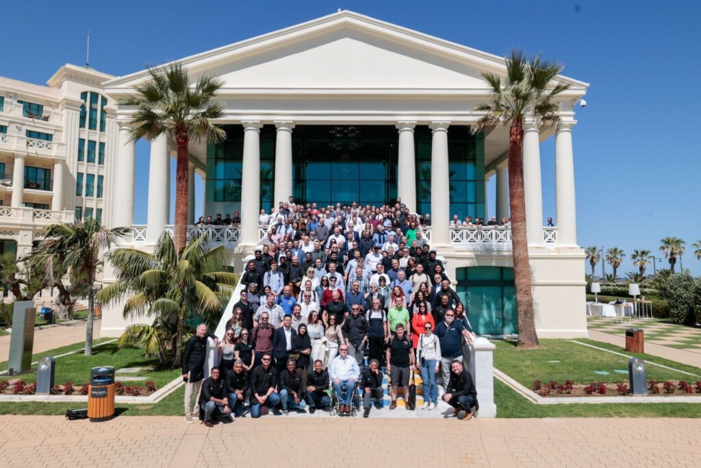 Group photo of Zoho and Caldere staff outside a grand building during Zoholics 2024 in Valencia.
